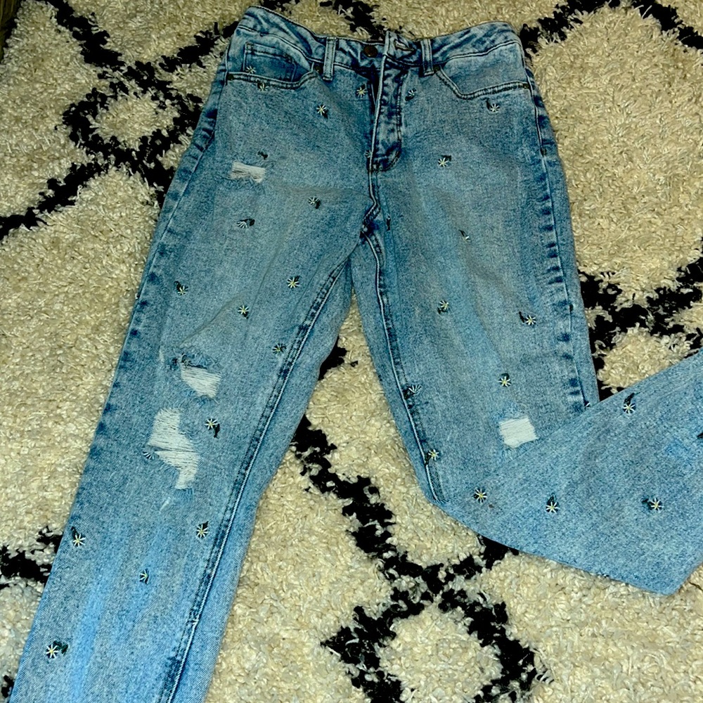 Light colored Jeans with Sunflower’s. Little rips of the knees, Top right thigh
